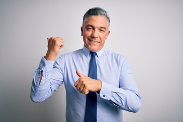 Middle age handsome grey-haired business man wearing elegant shirt and tie Pointing to the back behind with hand and thumbs up, smiling confident