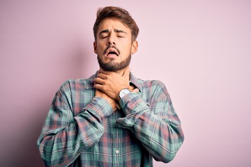 Fototapeta premium Young handsome man with beard wearing casual shirt standing over pink background shouting and suffocate because painful strangle. Health problem. Asphyxiate and suicide concept.