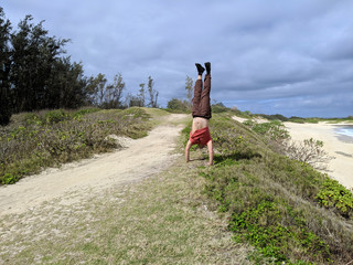 Man Handstands on beach bluff
