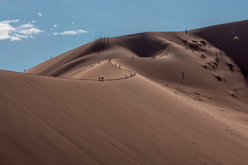 Fototapeta na wymiar People climbing Large Dunes in Namib Naukluft National Park, Namibia
