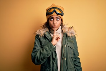 Young african american afro skier girl wearing snow sportswear and ski goggles Thinking concentrated about doubt with finger on chin and looking up wondering