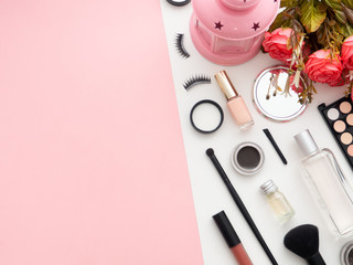 Makeup tools cosmetics on white and pink