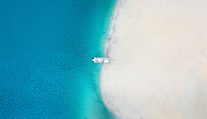 Aerial seascape view of boat in transparent blue water and white beach in summer tropical paradise...