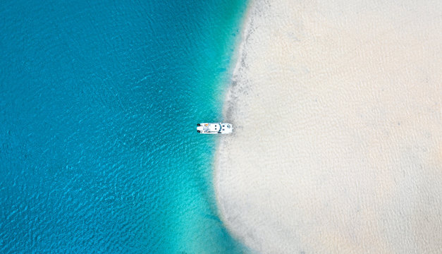 Aerial seascape view of boat in transparent blue water and white beach in summer tropical paradise island sand bar. 