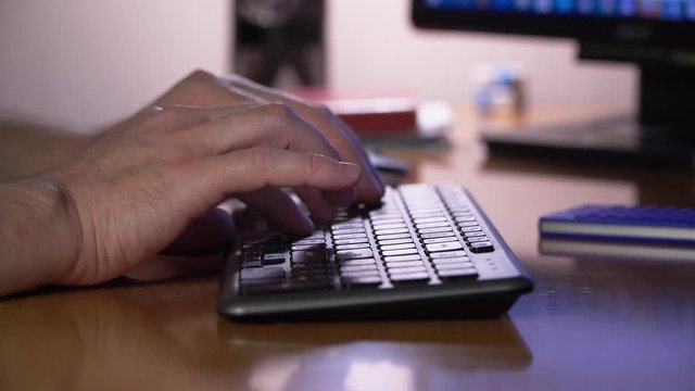 A man is typing on a keyboard. Freelancer works from home
