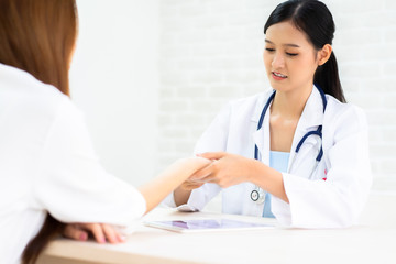 Female doctor talking to patient.Doctor and patient discussing something while sitting at the table...