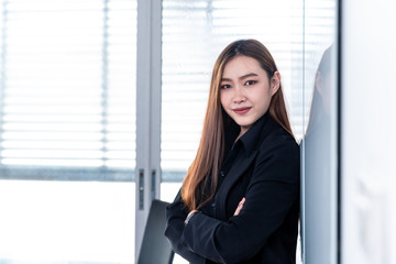 Asian business woman standing witn confidence post
