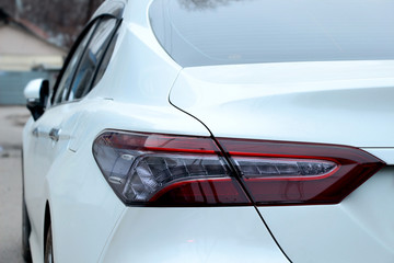 Naklejka premium Red headlight on a white car
