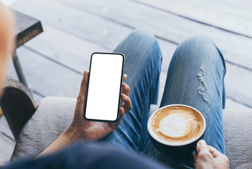 cell phone Mockup image blank white screen.woman hand holding texting using mobile on desk at coffee shop.background empty space for advertise text.people contact marketing business,technology
