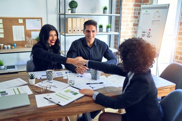 Group of business workers smiling happy and confident. Working together with smile on face shaking hands for agreement at the office