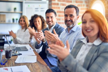 Group of business workers smiling happy and confident. Working together with smile on face looking at the camera applauding at the office