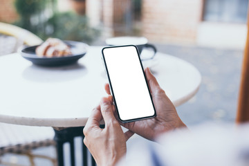 cell phone Mockup image blank white screen.woman hand holding texting using mobile on desk at coffee shop.background empty space for advertise text.people contact marketing business,technology
