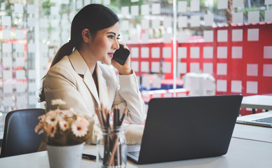 
Concept business woman working and people happy businesswoman or creative female office worker with computers writing to notebook with documents and laptop.
