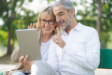 Technology connect and modern elderly lifestyles concept. Aged senior couple waving hands greeting...