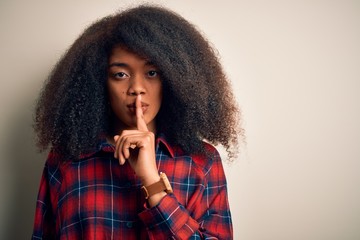 Fototapeta na wymiar Young beautiful african american woman wearing casual shirt over isolated background asking to be quiet with finger on lips. Silence and secret concept.