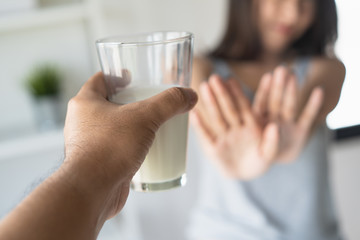 lactose intolerance concept. Woman holding a glass of milk and having a stomachache.