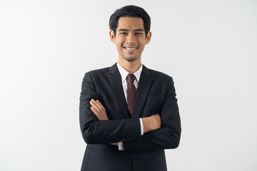 Obraz na płótnie Canvas happy young asian businessman smiling and folded arms in formal suit isolated on white background.
