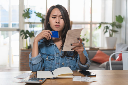 Woman doing accounting home finance expenses and calculate credit card monthly debt to bills payment.