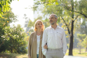 Elderly couple lifestyle concept. Husband and wife and sit walking in the park.