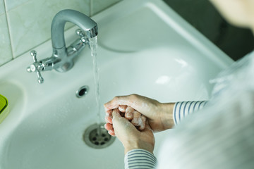 Female washing hands on sink. Hygiene and Healthcare concept. Cleaning hands with soap and water. Preventing diseases by washing your hands. Against novel coronavirus, Corona Virus Disease (Covid-19)