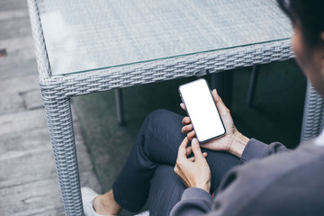 Obraz premium cell phone Mockup image blank white screen.woman hand holding texting using mobile on desk at coffee shop.background empty space for advertise text.people contact marketing business,technology