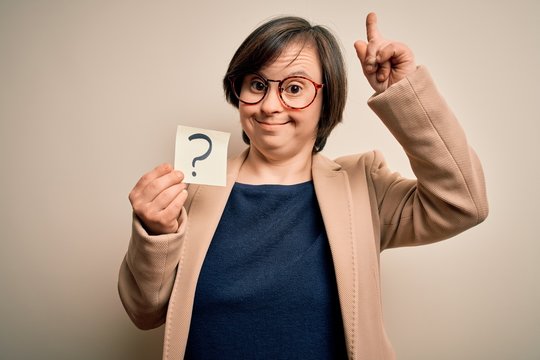 Young down syndrome business woman holding question mark paper as doubt symbol surprised with an idea or question pointing finger with happy face, number one