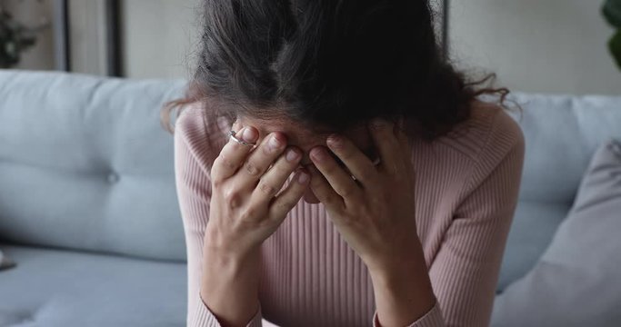 Depressed disappointed young woman taking off wedding engagement ring regrets unhappy marriage mistake. Upset frustrated wife thinking of divorce makes difficult decision about break up. Close up view
