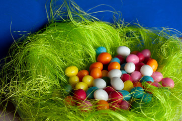 a heap of colorful candy eggs in easter nest