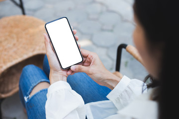 cell phone Mockup image blank white screen.woman hand holding texting using mobile on desk at coffee shop.background empty space for advertise text.people contact marketing business,technology