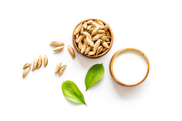 Alternative milk made from almond. Drink near unpeeled on white table top-down