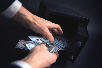 Cash Money Safe Deposit. Symbol of money safety. The man withdraw dollars from small Residential...