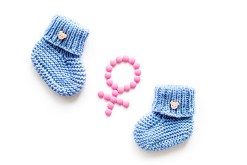 Baby booties for girl - pregnancy concept with Venus sign - on white background top-down