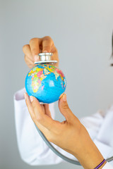 Pandemic concept, close up of scientist holding and analyzing planet earth