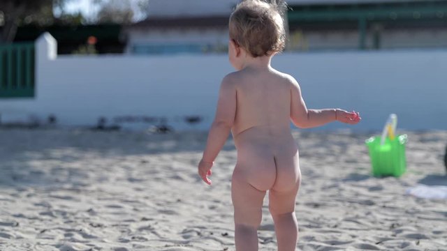 beautiful baby girl playing on a beach