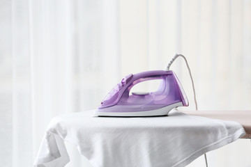 Electric iron and clothes on board at home