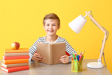 Cute little boy doing homework at table