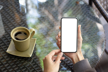 cell phone Mockup image blank white screen.woman hand holding texting using mobile on desk at coffee shop.background empty space for advertise text.people contact marketing business,technology