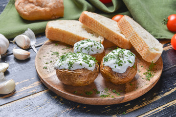 Tasty baked potato with sour cream and bread on table