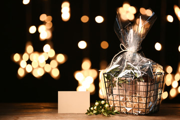Basket with gifts for Mother's Day on table against dark background