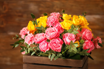 Box with flowers for Mother's Day on wooden background