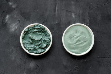 Blue cosmetic clay on black background top-down