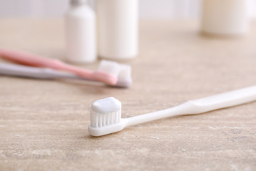Tooth brush with paste on table in bathroom
