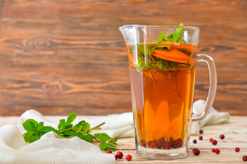 Jug of tasty cold tea on wooden table