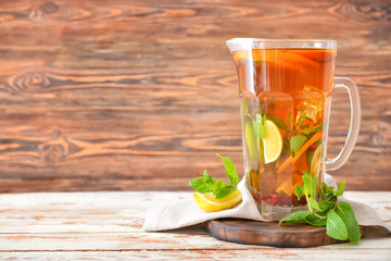 Jug of tasty cold tea on wooden table