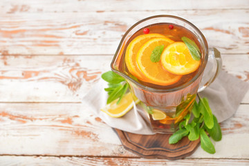 Jug of tasty cold tea on wooden table