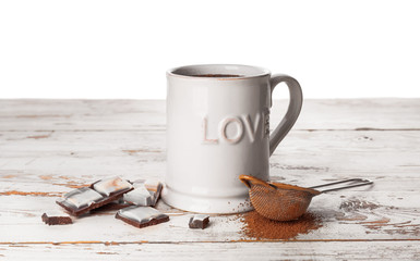 Cup of hot chocolate on table against white background
