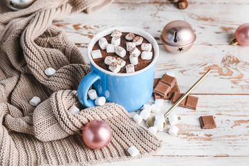 Cup of hot chocolate with marshmallows and Christmas decor on wooden table