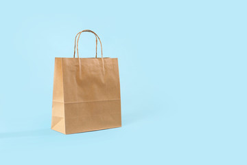 Paper shopping bag on color background