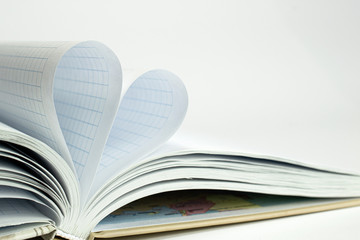 The form of heart from two pages of exercise book in a cell that becomes one heart shape. I love school clean and blurred background.