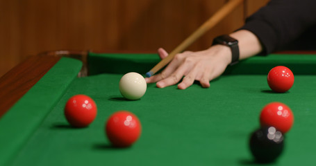 Striking snooker ball on table